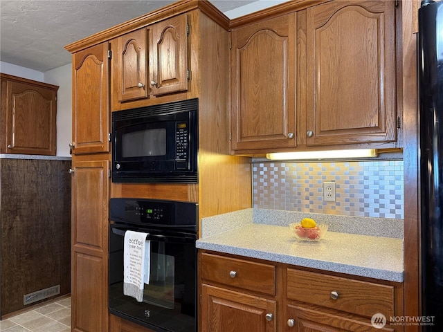 4208 W Okanogan Ave, Kennewick, WA 99336 - kitchen with black appliances, tasteful backsplash, and brown cabinets
