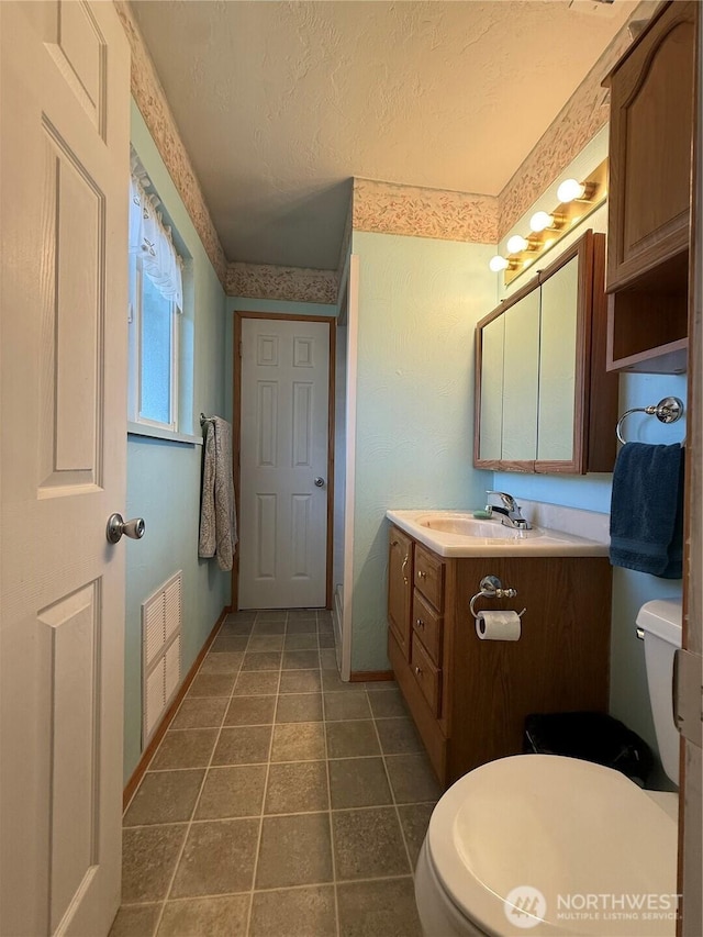 4208 W Okanogan Ave, Kennewick, WA 99336 - bathroom featuring toilet, vanity, a textured ceiling, and baseboards