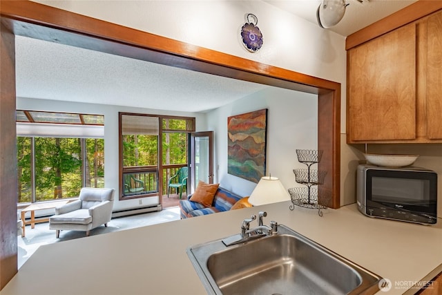 10500 Mt Baker Hwy Unit 905, Deming, WA 98244 - kitchen with a baseboard radiator, open floor plan, black microwave, brown cabinets, and light countertops