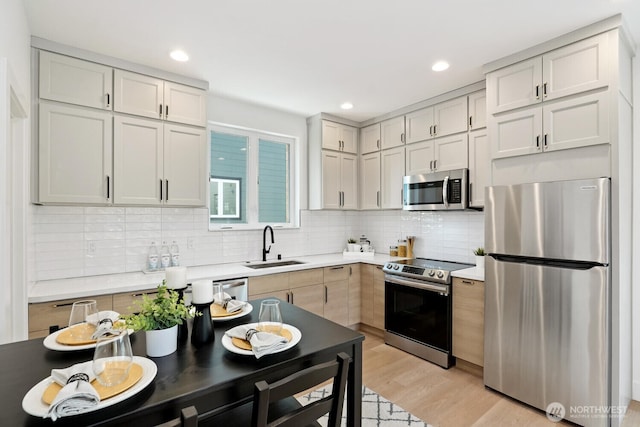 931 N 92nd St Unit B, Seattle, WA 98103 - kitchen featuring stainless steel appliances, a sink, backsplash, light wood-type flooring, and light countertops
