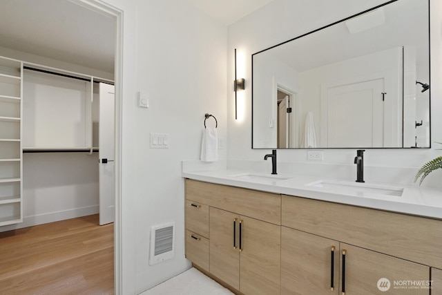 931 N 92nd St Unit B, Seattle, WA 98103 - full bathroom with double vanity, wood finished floors, a walk in closet, and baseboards