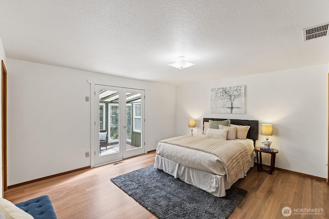 1443 U St, Port Townsend, WA 98368 - bedroom featuring access to exterior, wood finished floors, and a textured ceiling