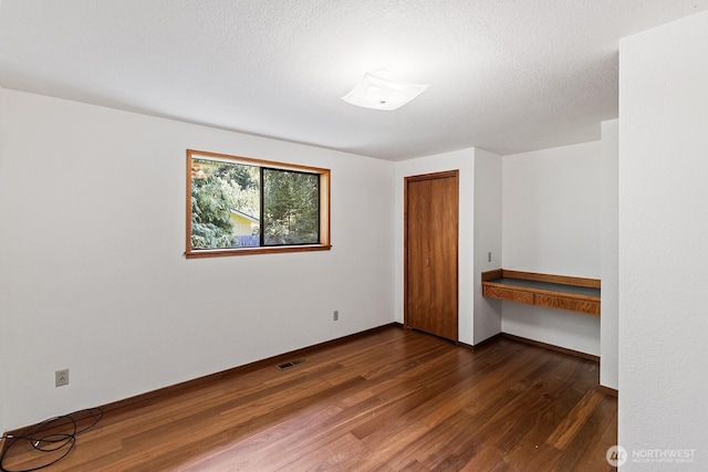 1443 U St, Port Townsend, WA 98368 - spare room featuring dark wood-style floors and built in desk