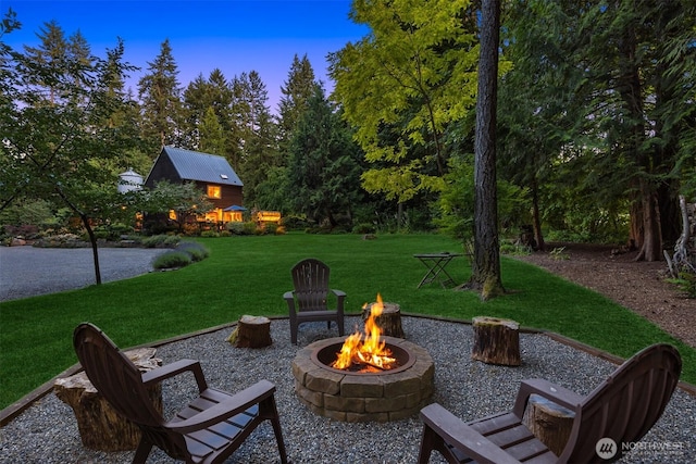 9000 NE Hidden Cove Rd, Bainbridge Island, WA 98110 - patio terrace at dusk with a fire pit, a lawn, and a water view