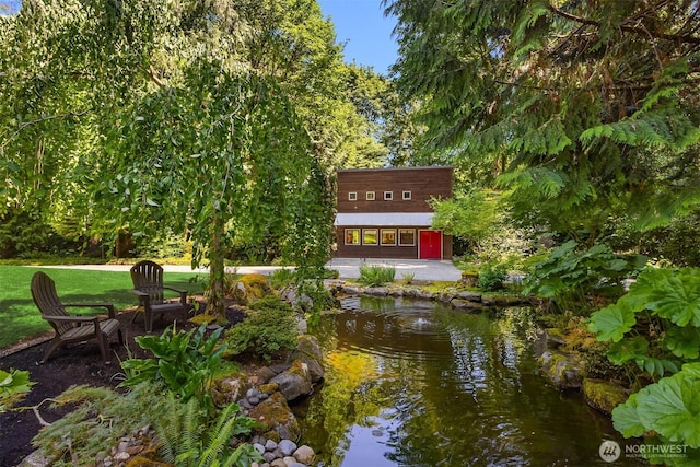 9000 NE Hidden Cove Rd, Bainbridge Island, WA 98110 - view of home's community featuring a lawn and a garden pond