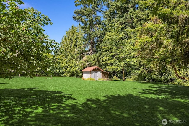 9000 NE Hidden Cove Rd, Bainbridge Island, WA 98110 - view of grassy yard with a storage shed and a wooded view