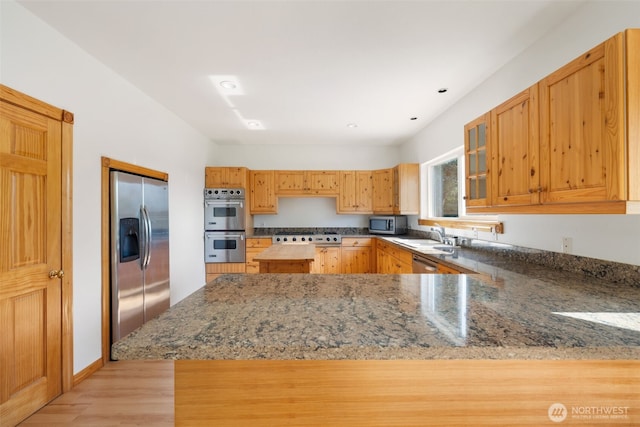 14502 45th St SW, Lakebay, WA 98349 - kitchen with appliances with stainless steel finishes, light wood-style flooring, a peninsula, dark stone countertops, and recessed lighting