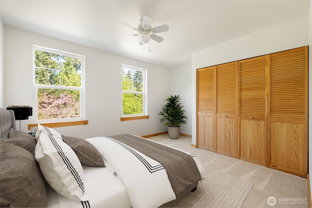 14502 45th St SW, Lakebay, WA 98349 - bedroom with light carpet, a ceiling fan, a closet, and baseboards