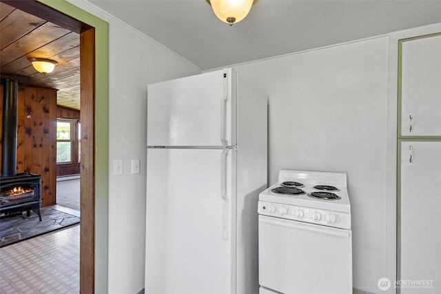 967 High Rd, Camano Island, WA 98282 - kitchen with white appliances, a wood stove, and a baseboard radiator