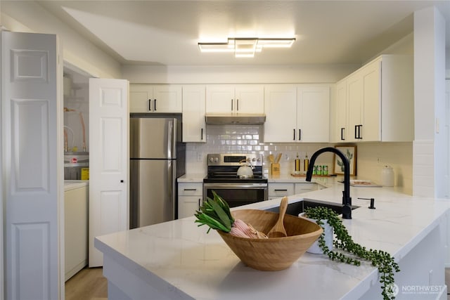 7711 NE 175th St Unit C106, Kenmore, WA 98028 - kitchen with stainless steel appliances, tasteful backsplash, light stone counters, and a peninsula