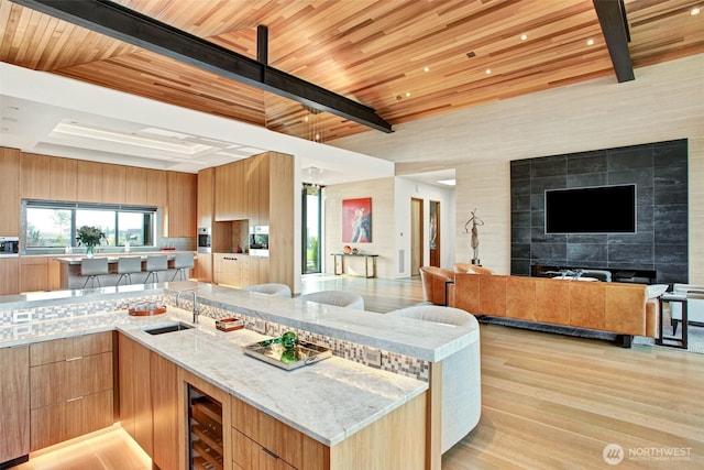 335 Brickwood Dr, Walla Walla, WA 99362 - kitchen with open floor plan, modern cabinets, light stone countertops, wine cooler, and a wood ceiling with exposed beams