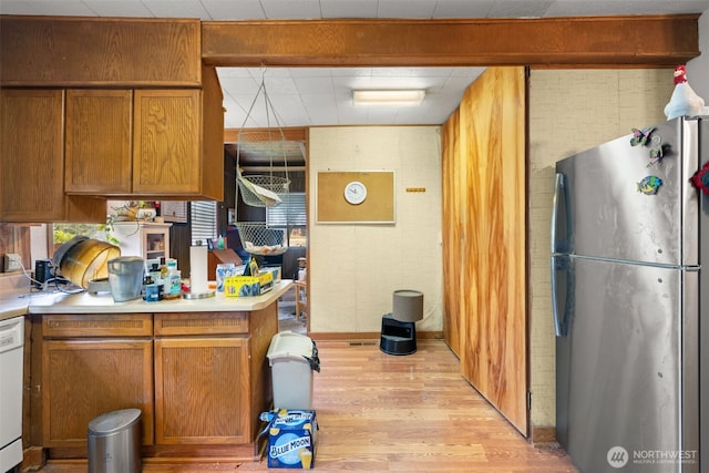 3626 E J St, Tacoma, WA 98404 - kitchen with freestanding refrigerator, light wood-style flooring, brown cabinets, and light countertops