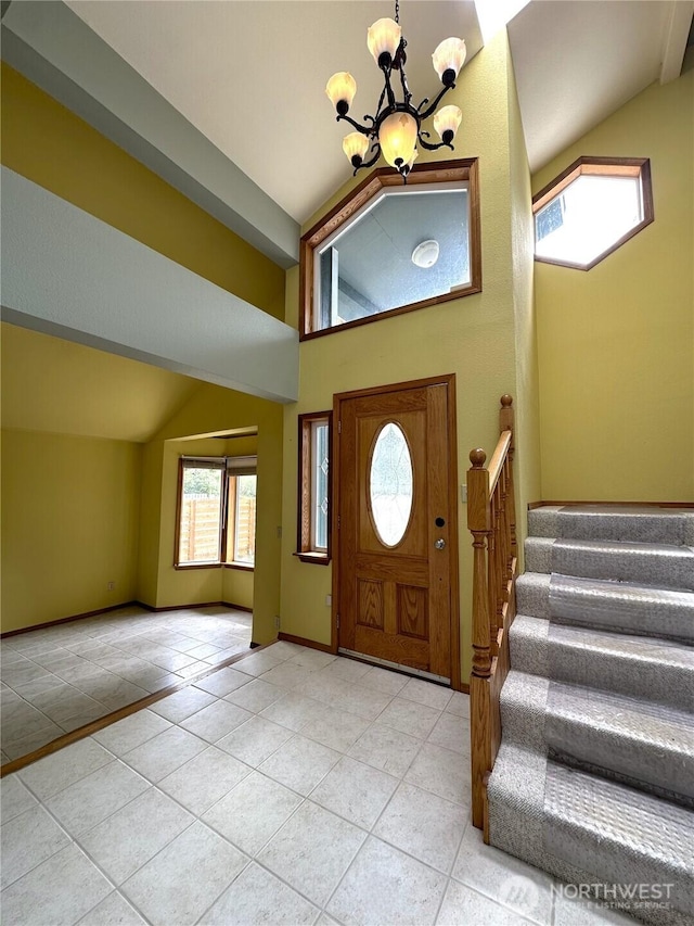 832 Whale Ct SW, Ocean Shores, WA 98569 - tiled foyer entrance featuring a chandelier, stairs, plenty of natural light, and a high ceiling