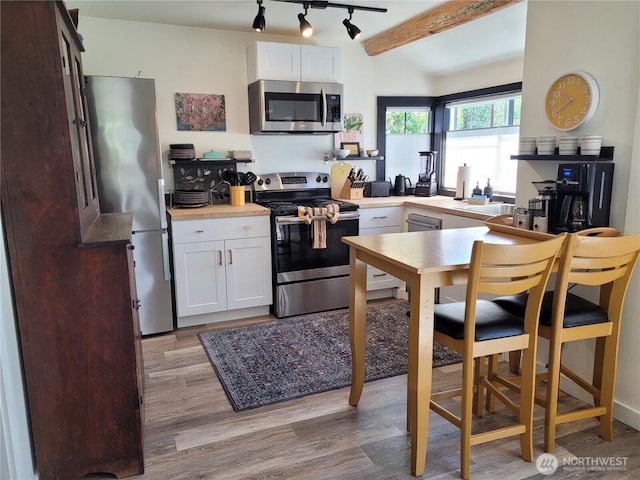 238 Castle Ave, Winthrop, WA 98862 - kitchen with stainless steel appliances, light wood-style floors, white cabinetry, and rail lighting