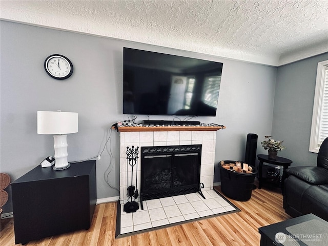 2036 30th Ave, Longview, WA 98632 - living area featuring wood finished floors, a textured ceiling, and a tiled fireplace