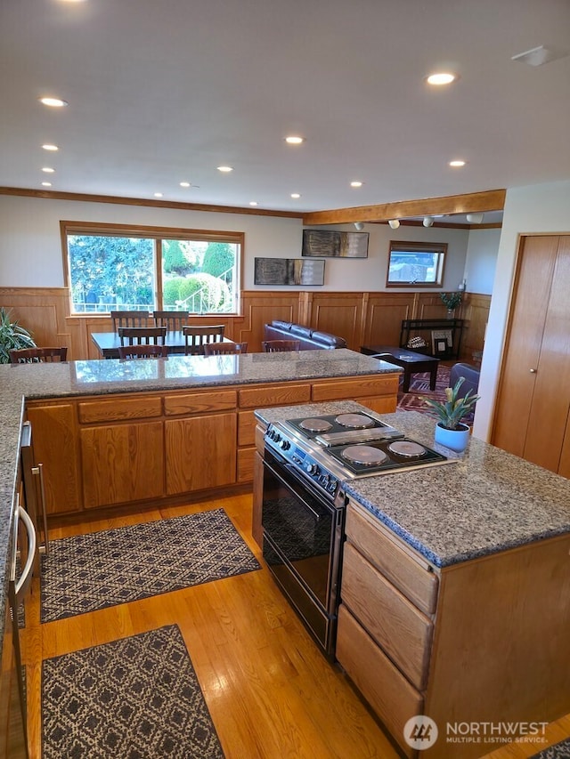 440 W Line Rd, Ephrata, WA 98823 - kitchen with black electric range, light wood finished floors, a wainscoted wall, brown cabinets, and recessed lighting