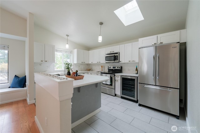 7309 46th Street Ct W, University Place, WA 98466 - kitchen featuring appliances with stainless steel finishes, wine cooler, lofted ceiling, a skylight, and light countertops