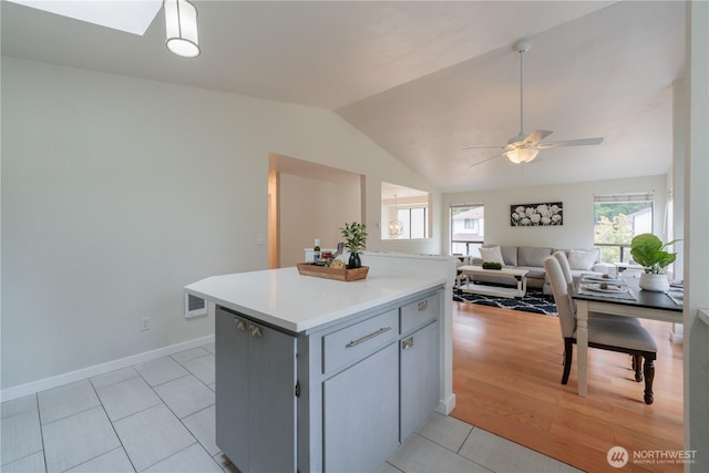 7309 46th Street Ct W, University Place, WA 98466 - kitchen with a ceiling fan, vaulted ceiling, light countertops, light tile patterned floors, and open floor plan