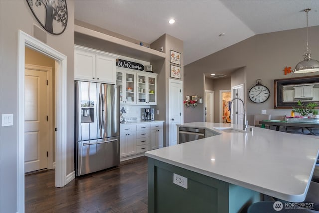 550 N Sparrow Ln, Moses Lake, WA 98837 - kitchen with stainless steel appliances, a sink, dark wood finished floors, white cabinetry, and vaulted ceiling