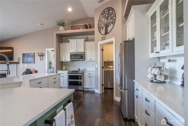 550 N Sparrow Ln, Moses Lake, WA 98837 - kitchen featuring vaulted ceiling, stainless steel appliances, backsplash, light countertops, and dark wood-type flooring