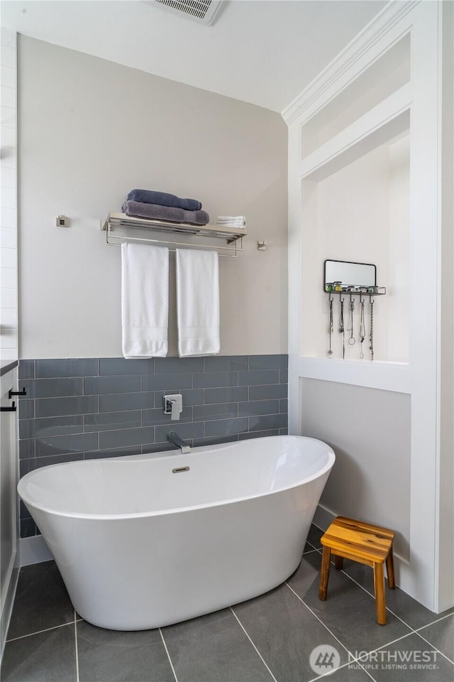 550 N Sparrow Ln, Moses Lake, WA 98837 - full bathroom with tile walls, tile patterned flooring, a soaking tub, and a wainscoted wall