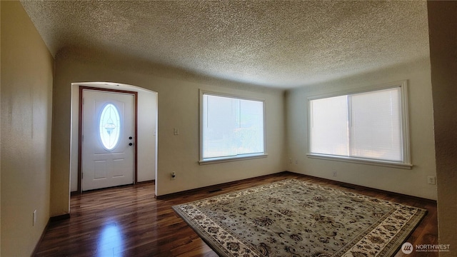 1618 112th St S, Parkland, WA 98444 - foyer entrance featuring dark wood-style floors, a textured ceiling, and arched walkways