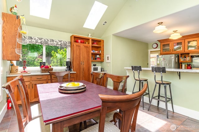 1833 3rd Ave, Kirkland, WA 98033 - dining room featuring a skylight, plenty of natural light, light tile patterned flooring, and high vaulted ceiling