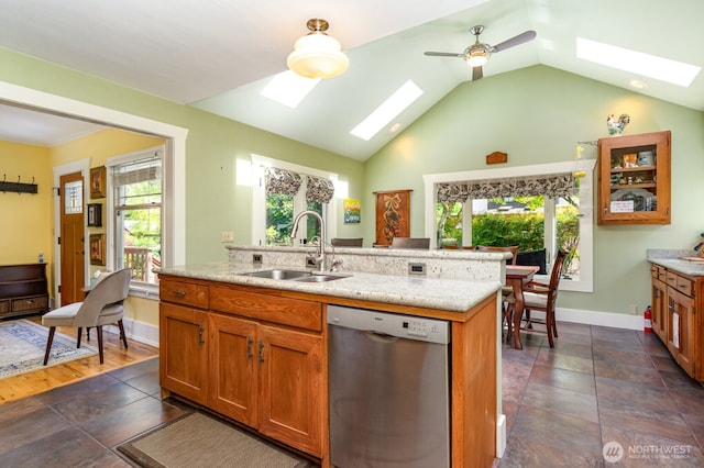 1833 3rd Ave, Kirkland, WA 98033 - kitchen with stainless steel dishwasher, a skylight, brown cabinetry, a ceiling fan, and vaulted ceiling