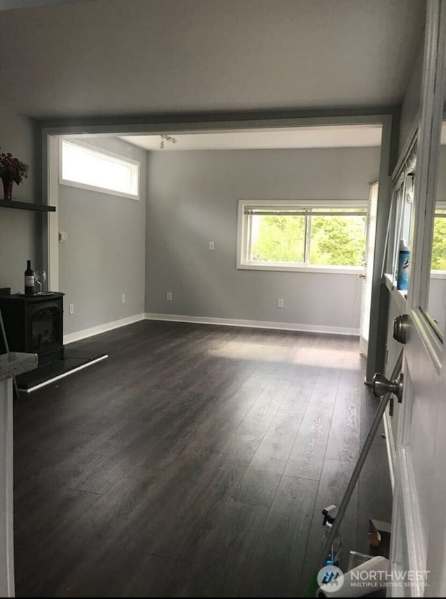 1833 3rd Ave, Kirkland, WA 98033 - unfurnished living room with a wood stove, healthy amount of natural light, and dark wood-style flooring