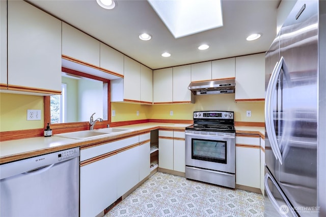 20135 Bue Rund Loop NE, Poulsbo, WA 98370 - kitchen with stainless steel appliances, under cabinet range hood, a sink, light countertops, and white cabinets