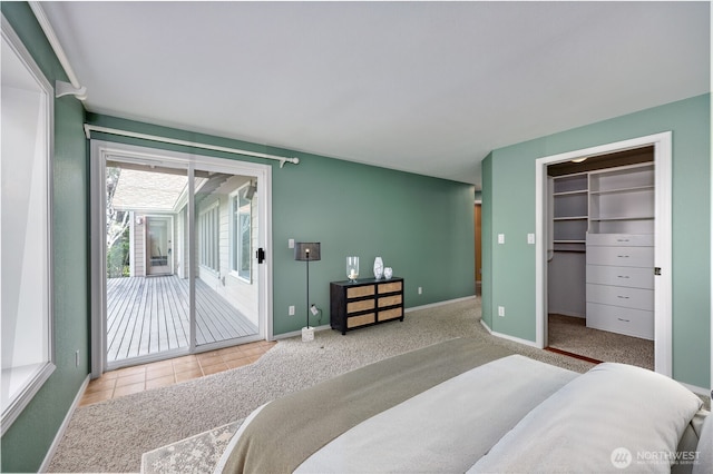 20135 Bue Rund Loop NE, Poulsbo, WA 98370 - bedroom featuring access to exterior, a spacious closet, carpet, baseboards, and tile patterned floors