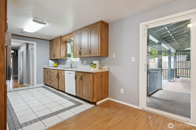 6836 Husky Way SE, Olympia, WA 98503 - kitchen with white dishwasher, light countertops, light wood-type flooring, and brown cabinets