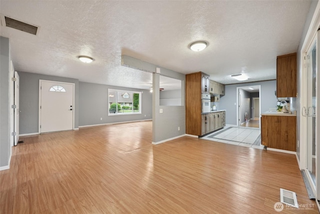6836 Husky Way SE, Olympia, WA 98503 - unfurnished living room featuring light wood finished floors and a textured ceiling