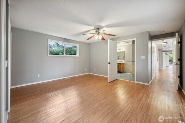 6836 Husky Way SE, Olympia, WA 98503 - unfurnished bedroom featuring light wood-style flooring, ensuite bath, and ceiling fan