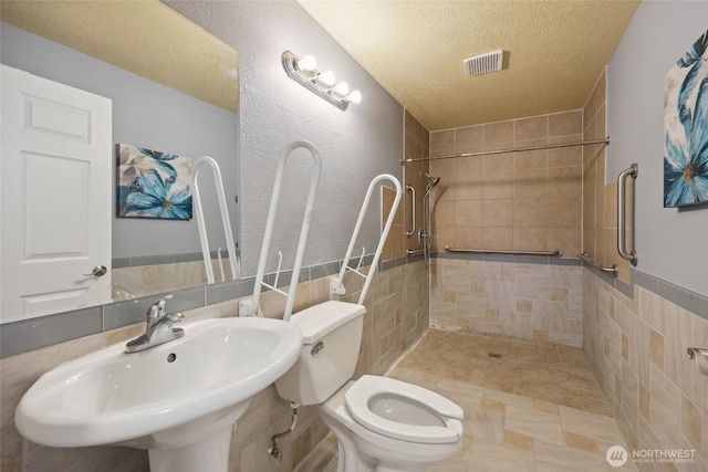 6836 Husky Way SE, Olympia, WA 98503 - full bath with a textured ceiling, a tile shower, and tile walls