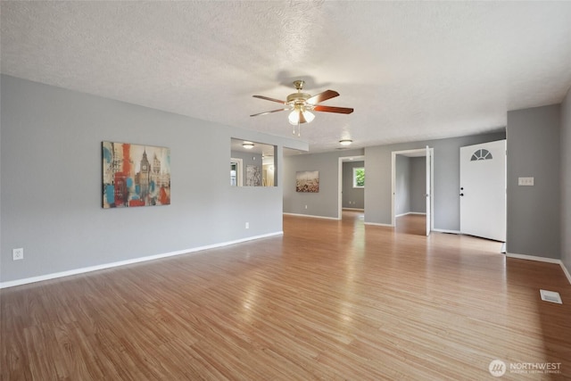 6836 Husky Way SE, Olympia, WA 98503 - unfurnished living room with light wood-style flooring, ceiling fan, and a textured ceiling