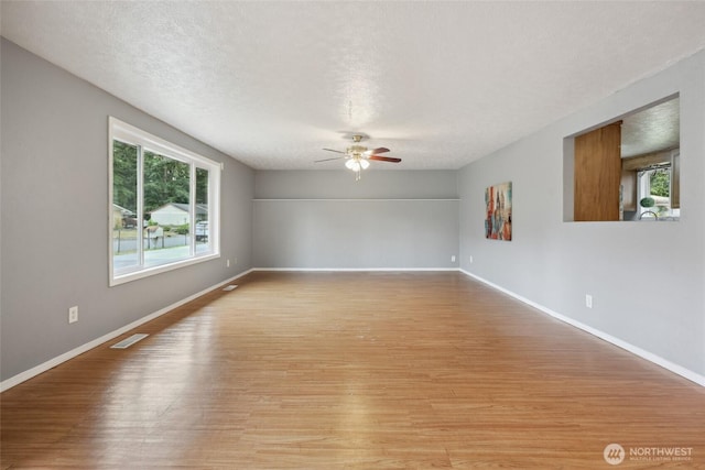 6836 Husky Way SE, Olympia, WA 98503 - spare room featuring plenty of natural light, light wood-style floors, a ceiling fan, and a textured ceiling