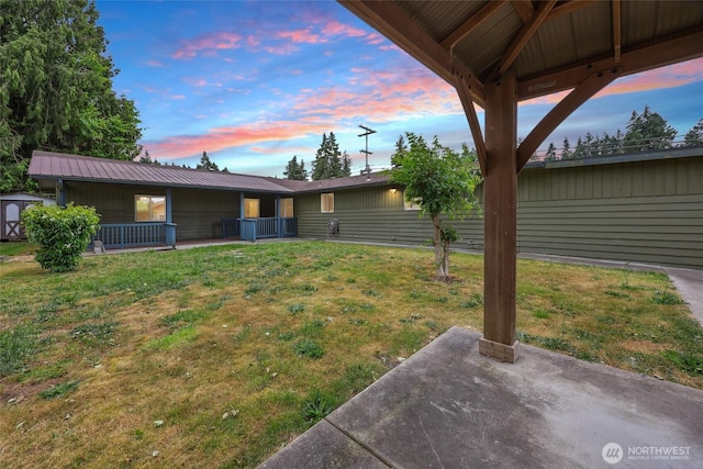6836 Husky Way SE, Olympia, WA 98503 - yard at dusk with a yard, covered porch, a patio, and a storage shed