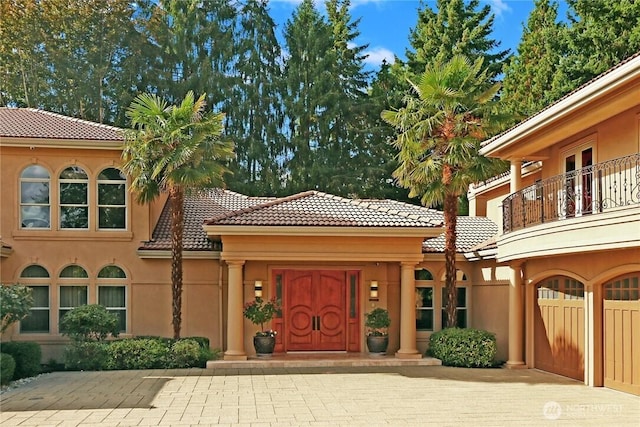 1055 91st Ave NE, Bellevue, WA 98004 - property entrance featuring a tile roof, a balcony, and stucco siding