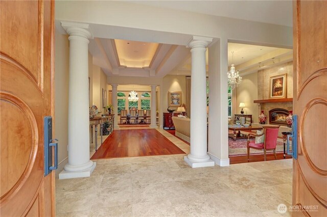 1055 91st Ave NE, Bellevue, WA 98004 - foyer with a chandelier, a large fireplace, and a tray ceiling