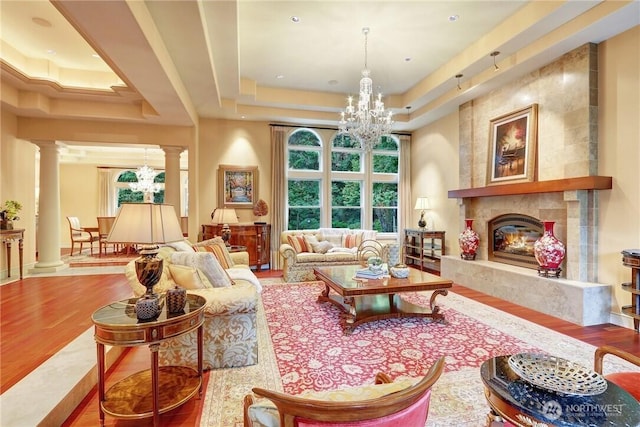 1055 91st Ave NE, Bellevue, WA 98004 - living area with a tray ceiling, decorative columns, a chandelier, wood finished floors, and a high end fireplace