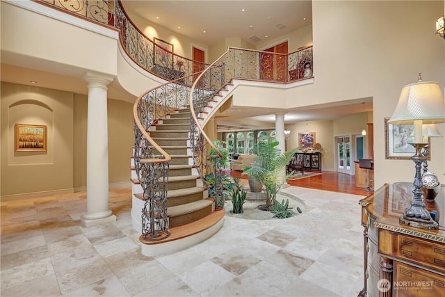 1055 91st Ave NE, Bellevue, WA 98004 - stairs featuring decorative columns, a towering ceiling, and baseboards
