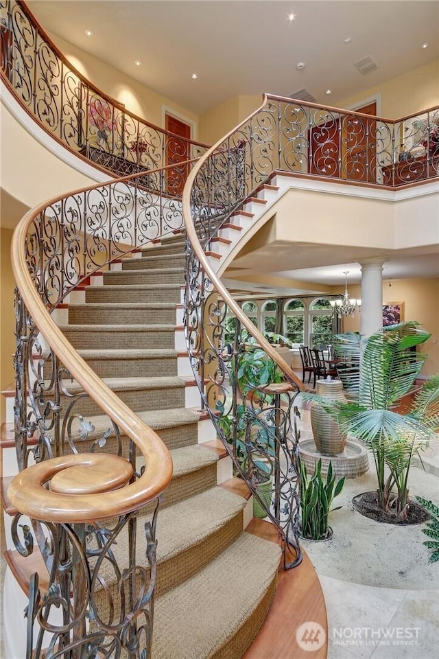 1055 91st Ave NE, Bellevue, WA 98004 - stairway featuring a high ceiling, ornate columns, recessed lighting, and a chandelier