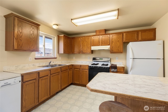 2376 Nicholas Dr, Ferndale, WA 98248 - kitchen featuring white appliances, under cabinet range hood, light countertops, brown cabinetry, and a breakfast bar area
