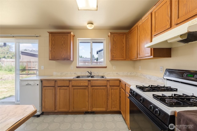 2376 Nicholas Dr, Ferndale, WA 98248 - kitchen featuring range with gas cooktop, dishwasher, under cabinet range hood, light countertops, and brown cabinetry