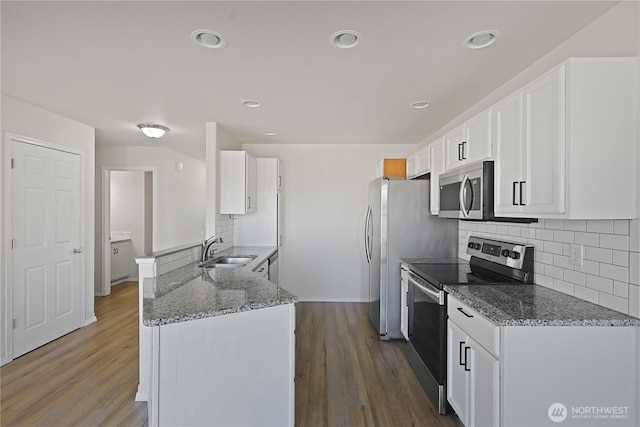 16550 Greenleaf Ave SE, Yelm, WA 98597 - kitchen featuring stainless steel appliances, a sink, white cabinetry, a peninsula, and backsplash