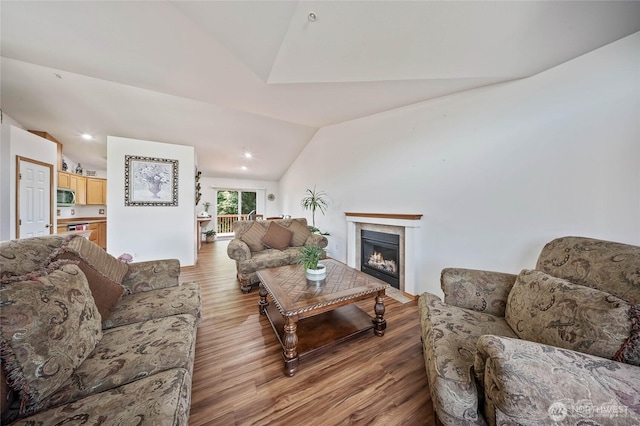 2427 Bellanca Ct, East Wenatchee, WA 98802 - living area featuring lofted ceiling, wood finished floors, and a fireplace with flush hearth