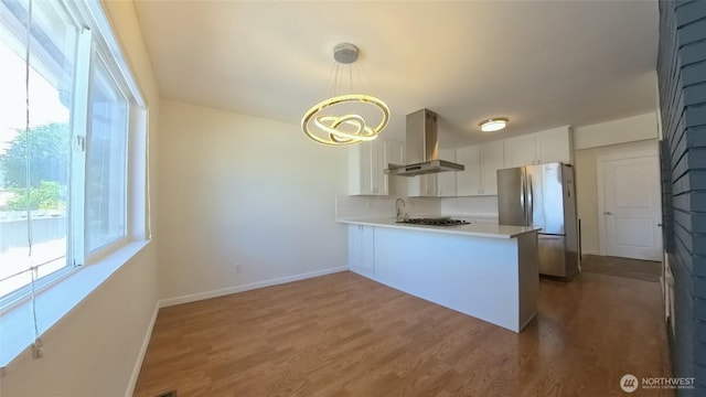 30022 2nd Pl SW, Federal Way, WA 98032 - kitchen featuring wall chimney range hood, freestanding refrigerator, a peninsula, white cabinetry, and light countertops