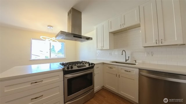30022 2nd Pl SW, Federal Way, WA 98032 - kitchen featuring appliances with stainless steel finishes, island exhaust hood, light countertops, tasteful backsplash, and white cabinets