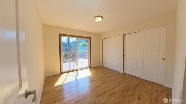 30022 2nd Pl SW, Federal Way, WA 98032 - unfurnished bedroom featuring access to outside, light wood finished floors, and multiple closets